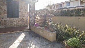 A stone building with a window and a metal gate. - Aria di Vacanza - Maltineddu COD 23 (Olbia)