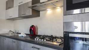 A modern kitchen with stainless steel appliances, a gas stove, and a built-in oven.