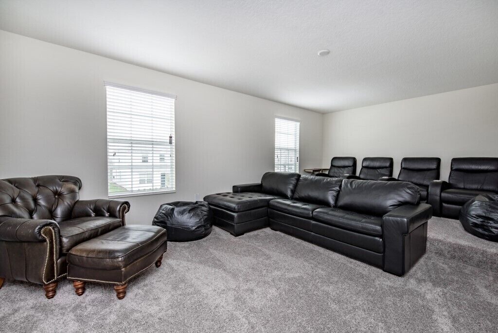 A living room with a sectional sofa, a chaise lounge, and a small ottoman.