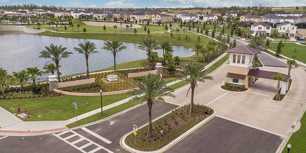 Zona residencial con un lago, palmeras y casas.