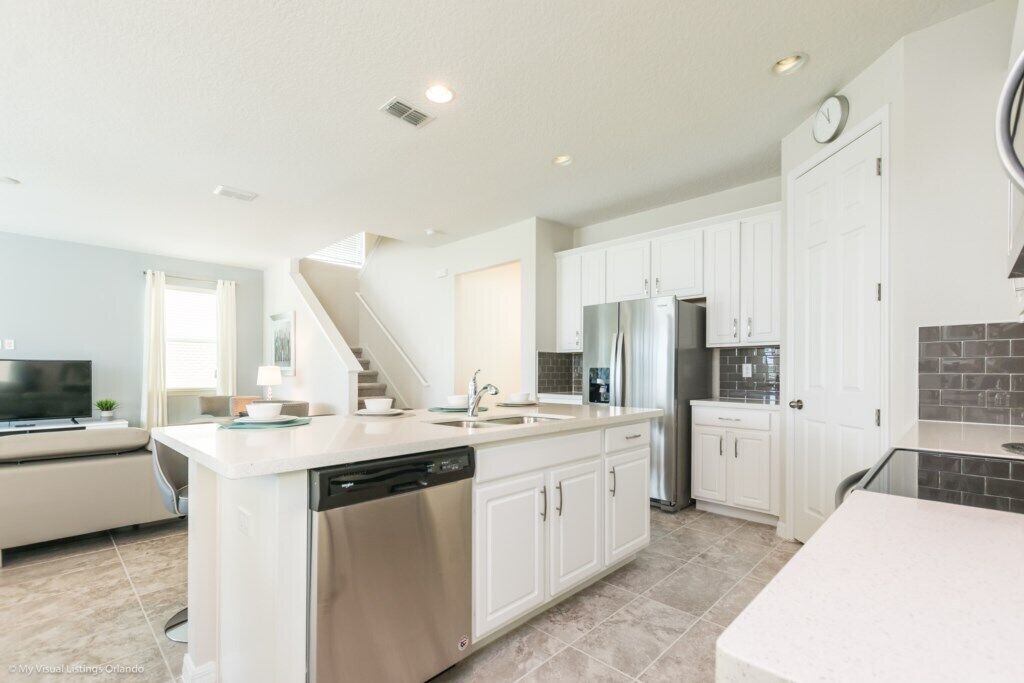 A modern kitchen with white cabinetry, stainless steel appliances, and a dishwasher.