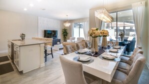 A modern dining area with a large table set for six, surrounded by comfortable seating. - Gorgeous Townhome In Champion's Gate Near Disney! 4 Bedroom Townhouse by RedAwning (Davenport)
