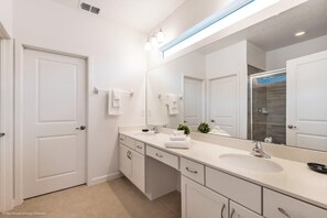 A modern bathroom with a large mirror, two sinks, and white cabinetry. - 2619ca 10 Bedroom Villa by Redawning (Kissimmee)