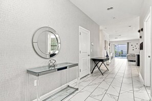 A modern bathroom with a glass vanity, a round mirror, and a tiled floor. - 1521MC Amazing Champions Gate 8 Bedroom 5 Bed Villa by RedAwning (Davenport)
