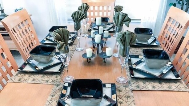 A dining table set with square plates, glasses, and folded napkins. - South Facing Pool Great For Families! 4 Bedroom Home by RedAwning (Haines City)