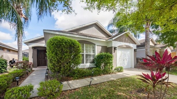 A single-story house with a front porch, a garage, and a well-maintained lawn.