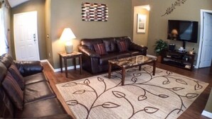 A living room with a brown leather sofa, a coffee table, and a patterned rug. - Perfect For Your Florida Vacation! 3 Bedroom Home by RedAwning (Haines City)