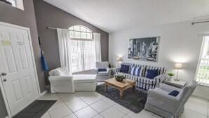 Un salon moderne avec un ensemble de canapés, une table basse et un tableau accroché au mur.