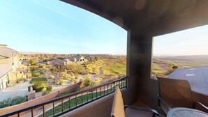 A balcony with a view of a landscaped area and distant buildings.