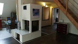 Un salon moderne doté d’une cheminée, d’un coin repas et d’un escalier.