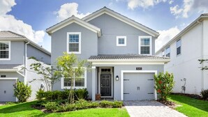 A two-story residential building with a grey facade, a front porch, and a garage. - 1585tempo 5 Bedroom Home by RedAwning (Davenport)