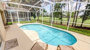 A covered swimming pool with a view of a golf course.
