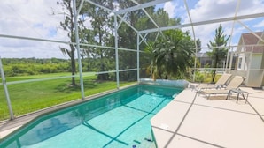 A swimming pool with a clear blue water, surrounded by a white fence, and a few lounge chairs. - Serene Private Pool In Southern Dunes! 4 Bedroom Home by RedAwning (Haines City)