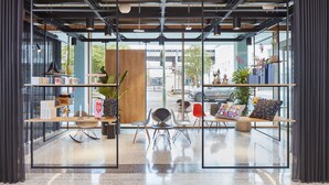 Ein modernes Interieur mit Glaswänden, einer Sitzecke inklusive Stühle und Tisch sowie verschiedenen Dekorationselementen.