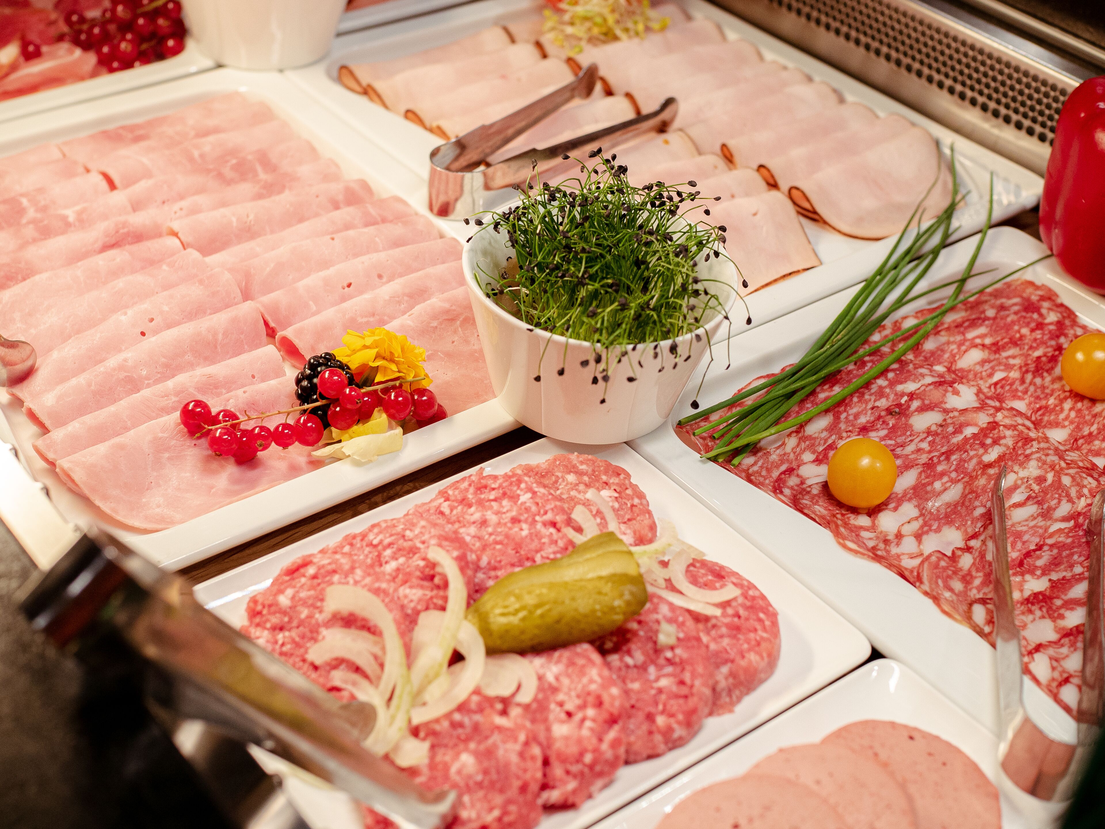 Variedad de cortes de carne y guarniciones a la vista.