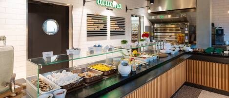 A buffet counter with various food items and a sign that reads "Acquina Italiana".