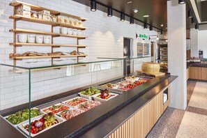 Een buffetgedeelte met diverse gerechten en een bakkerijplank.