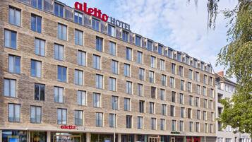 A modern hotel with a brick facade, multiple windows, and a clear sky.