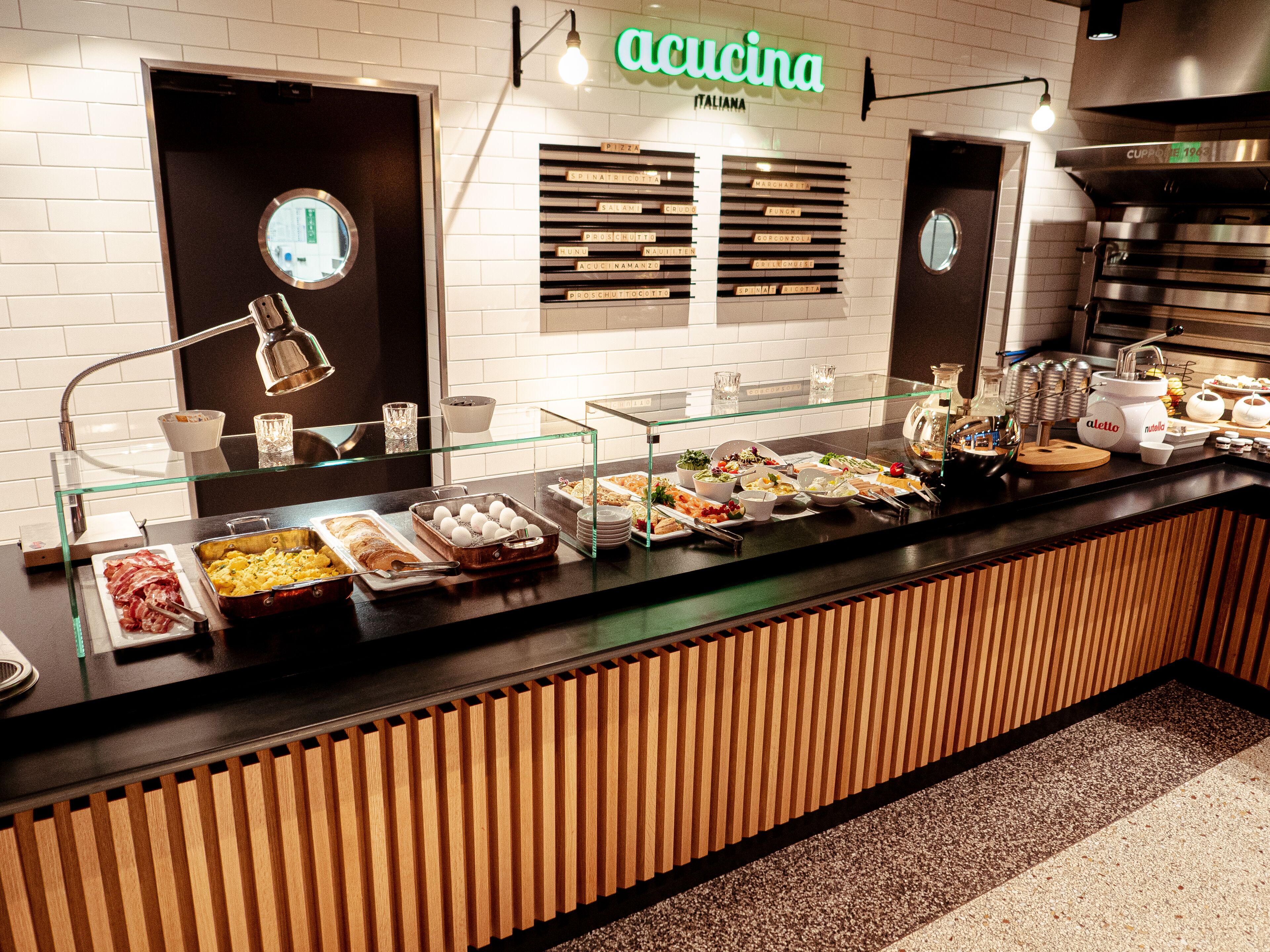 A buffet area with various food options, a coffee machine, and a sign that reads "cucina".