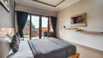 Quarto de hotel moderno com uma cama grande, uma televisão fixada na parede e uma varanda com vista para a cidade.