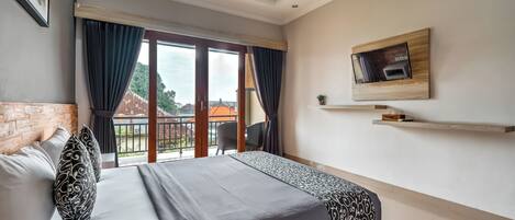 Quarto de hotel moderno com uma cama grande, uma televisão fixada na parede e uma varanda com vista para a cidade.