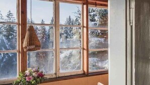 A wooden interior with a window, a table, and a chair. - Berghütte Innsbruck (Innsbruck)