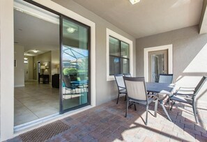 Enjoy dining or socializing in this spacious patio area with a table and four chairs.