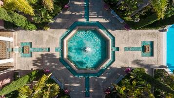 Una piscina al aire libre, sombrillas, tumbonas