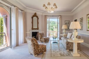 Un salón amplio con chimenea, asientos cómodos y vistas al exterior.