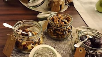 Un taulell amb diferents pots d'aliments, alguns amb etiquetes, i una pila de plats al fons.