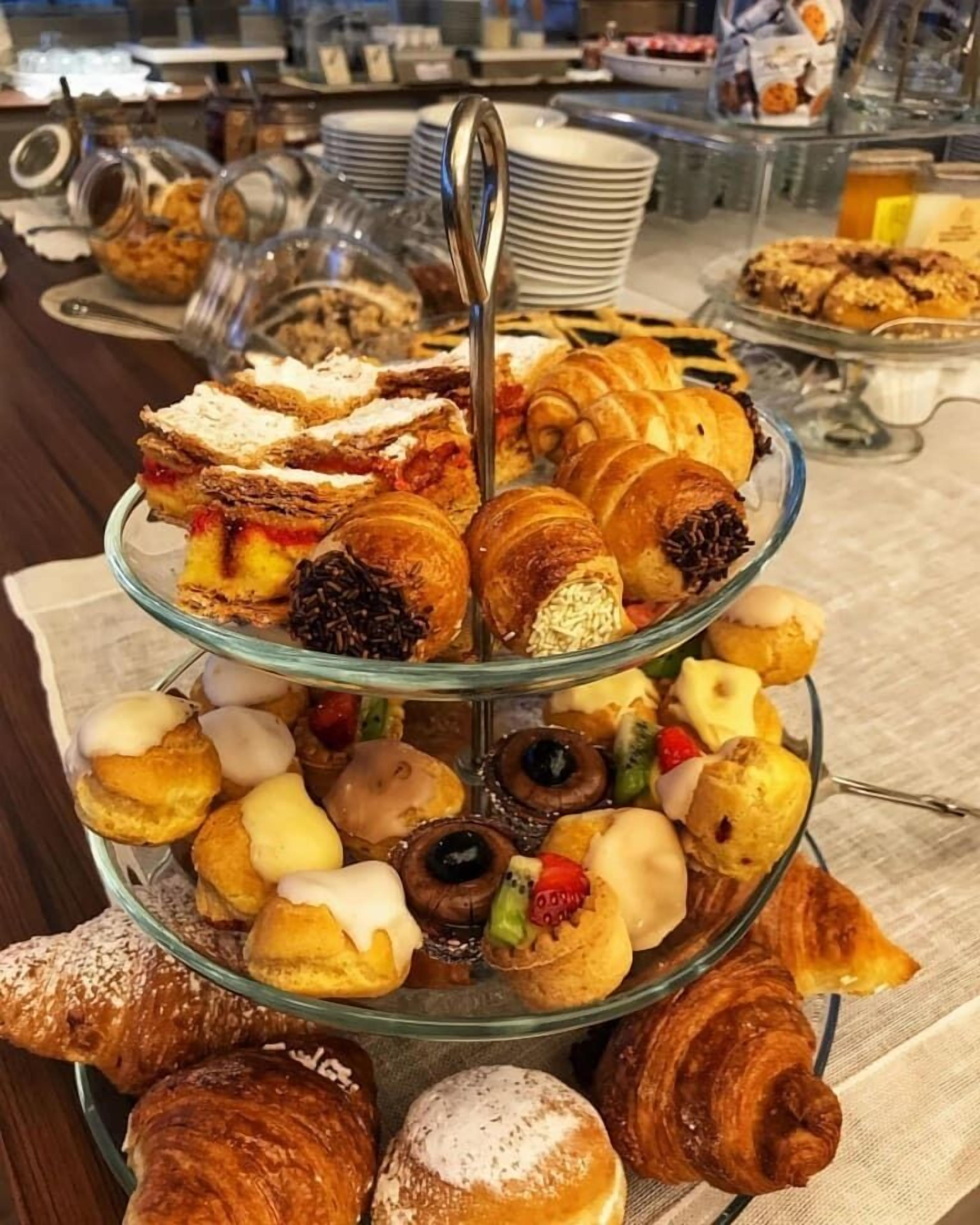 A multi-tiered dessert display with various pastries and cakes.
