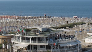 A coastal hotel with multiple decks, beachside seating, and a view of the sea. - Embassy Aparthotel (Rimini)