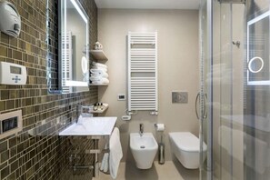Apartamento superior | Banheiro | Banheira e chuveiro separados, secador de cabelo, roupões de banho 
