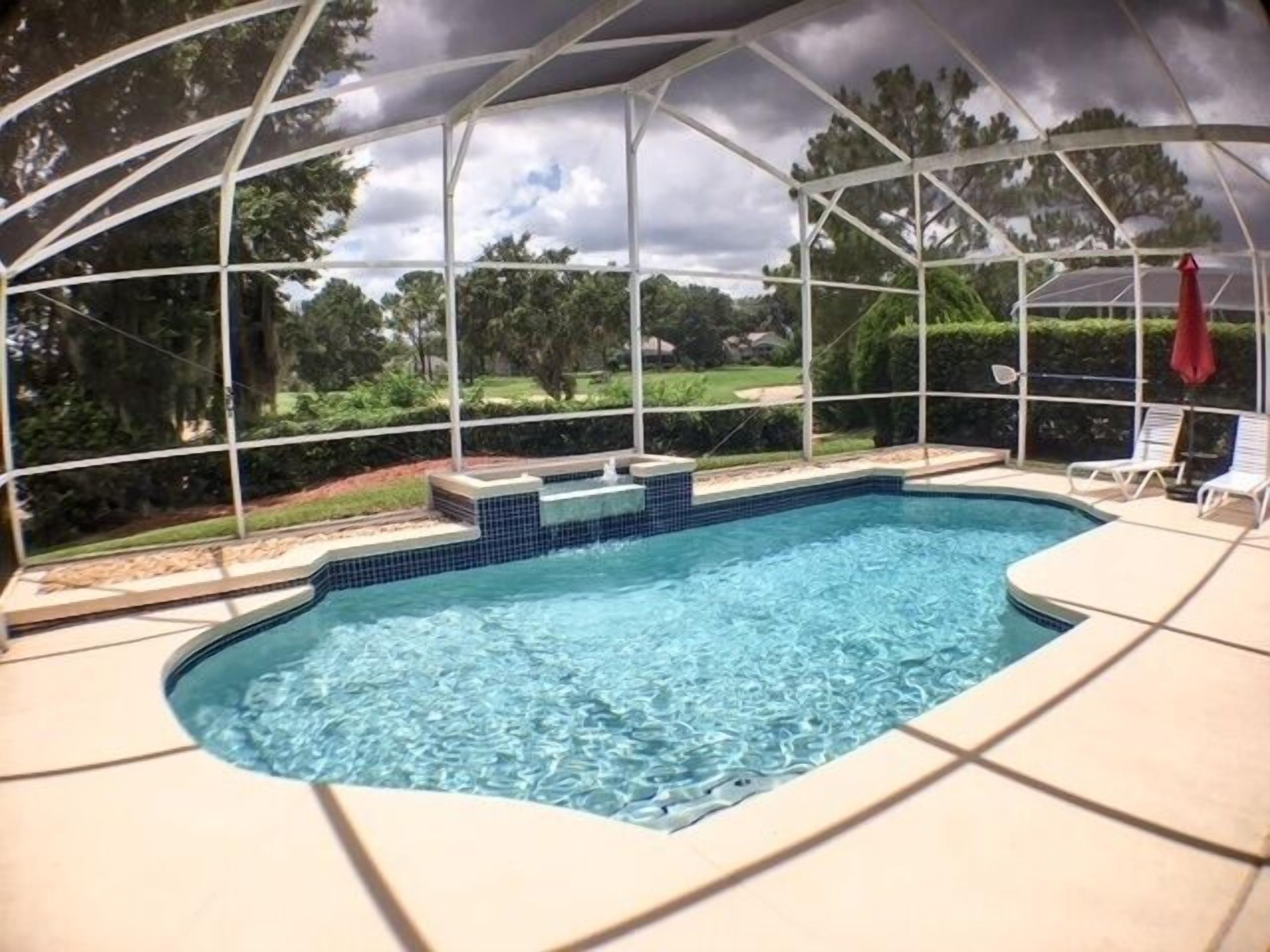 A covered swimming pool with a view of the surrounding landscape.