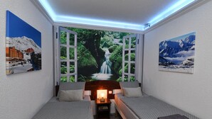 Una habitación acogedora con una cama, una mesita de noche y un ventanal con vistas a una cascada y follaje.