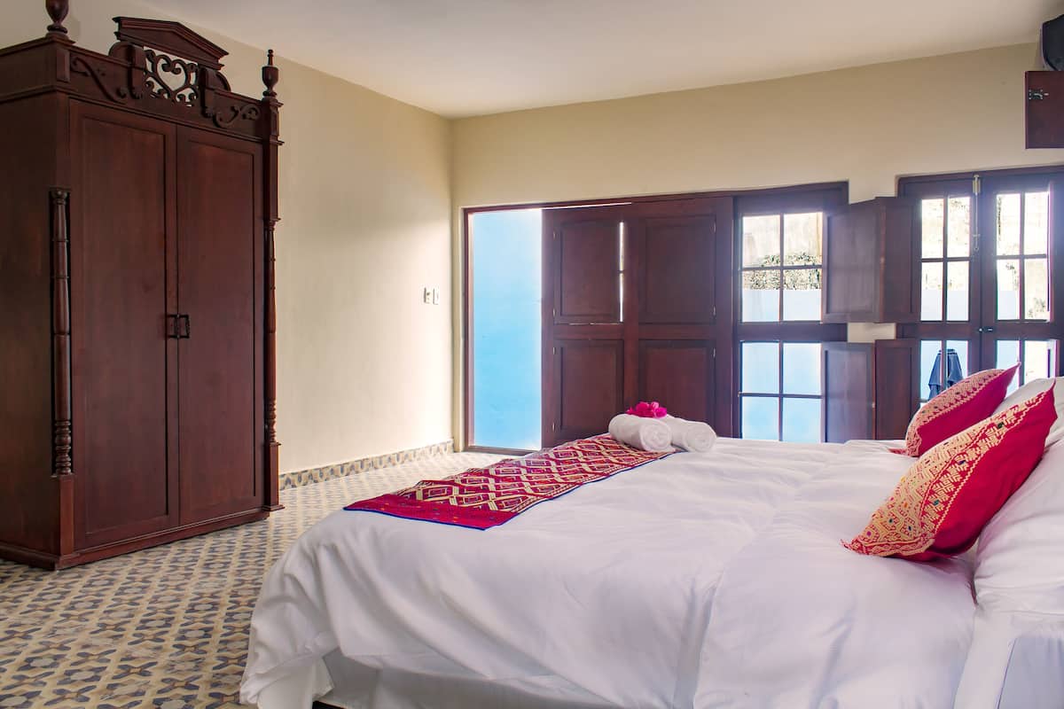 Una camera d'albergo con un letto grande, un armadio e vista sull'esterno.