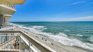 Ein Balkon mit Blick auf Strand und Meer.