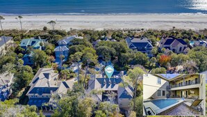 Zona residencial costera con casas, una playa y un cartel que indica una empresa de vacaciones.