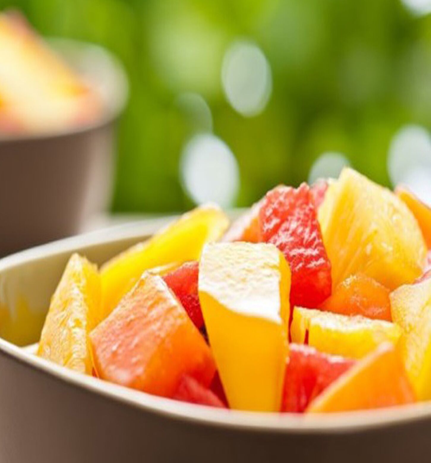 A bowl of mixed fruit including oranges and apples.