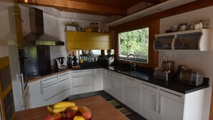 A modern kitchen with white cabinets, a wooden countertop, and a fruit bowl. - Luxury Chalet with Ski-In/Ski-Out, Sauna & Outdoor Jacuzzi at Le Grand-Bornand (Le Grand-Bornand)