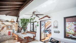 Ein gemütliches Wohnzimmer mit einer Holzbank, einem Tisch und einem Deckenventilator.
