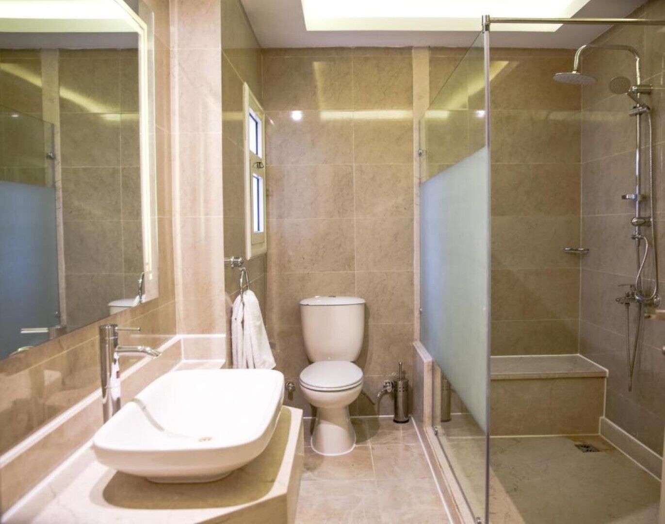 A modern bathroom with a freestanding bathtub, a toilet, and a glass-enclosed shower area.