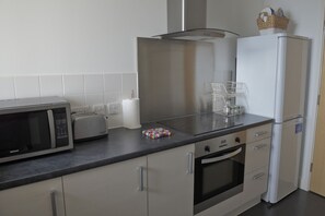 Een keuken met een magnetron, broodrooster en koelkast.