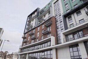 Een meerlaags woongebouw met balkons, grote ramen en een modern architectonisch ontwerp.