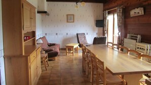 A rustic dining area with a wooden table and chairs, a sofa, and a cabinet. - Spacious Savoyard chalet apt, equipped kitchen, 4 bedrooms, 2 baths, Le Chinaillon (Le Grand-Bornand)