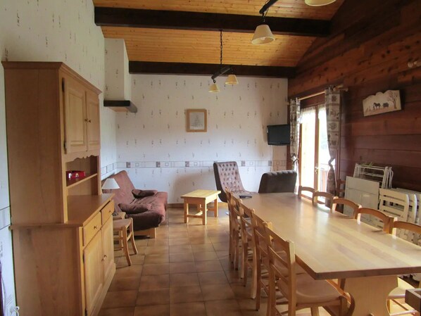 A rustic dining area with a wooden table and chairs, a sofa, and a cabinet. - Spacious Savoyard chalet apt, equipped kitchen, 4 bedrooms, 2 baths, Le Chinaillon (Le Grand-Bornand)