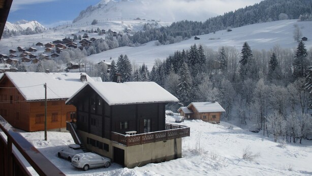 A snow-covered mountain village with wooden houses and a ski slope in the background. - Spacious Savoyard chalet apt, equipped kitchen, 4 bedrooms, 2 baths, Le Chinaillon (Le Grand-Bornand)