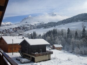 A snow-covered mountain village with wooden houses and a ski slope in the background. - Spacious Savoyard chalet apt, equipped kitchen, 4 bedrooms, 2 baths, Le Chinaillon (Le Grand-Bornand)