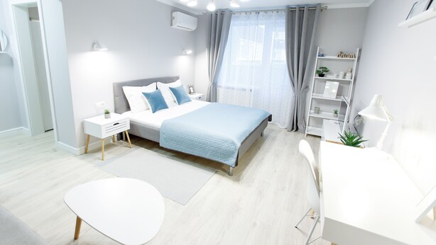 Un dormitorio moderno con cama, mesitas de noche, escritorio y silla.