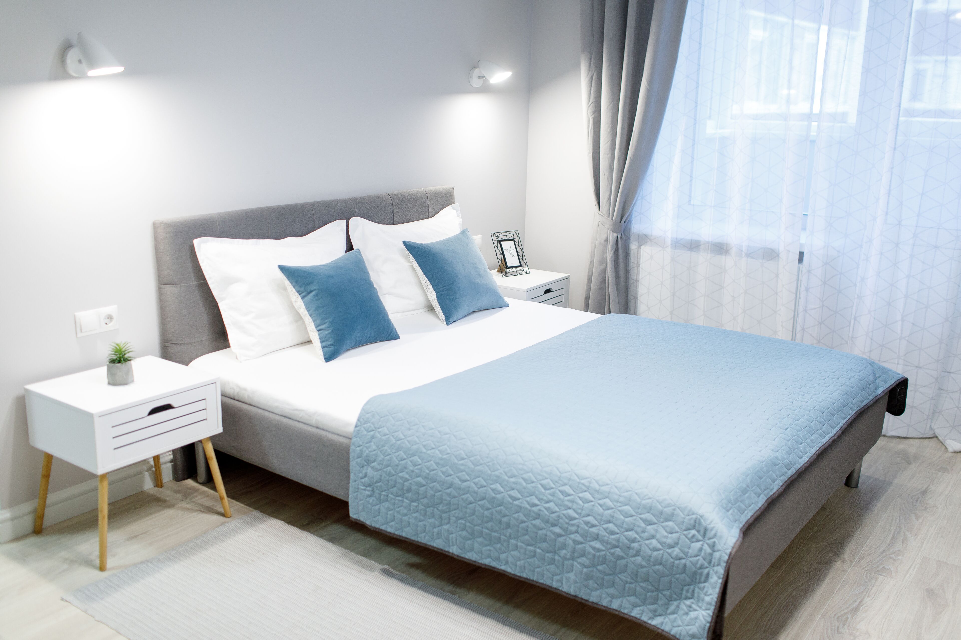 A modern bedroom with a bed, nightstands, and a bedside table.
